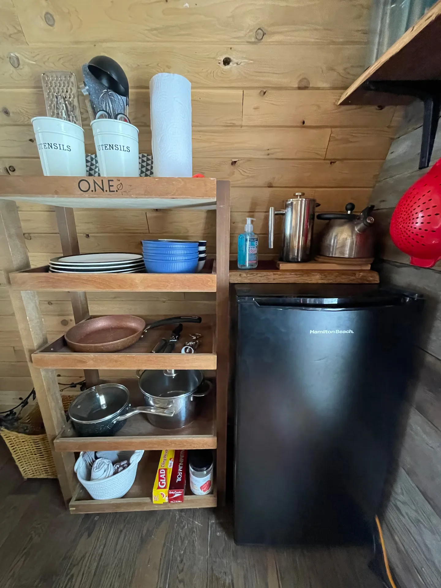Kitchen shelving with cookware and mini fridge