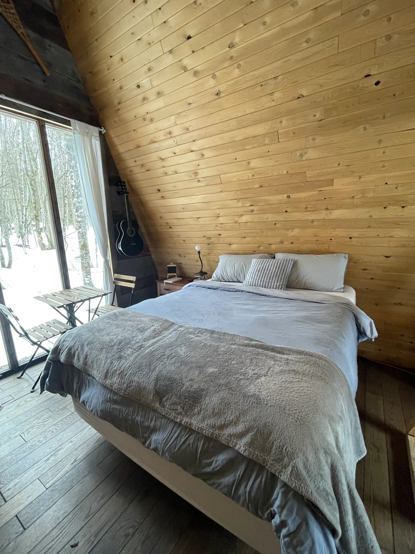 Interior bedroom with wood walls and forest view